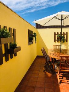 un patio con mesa, sillas y sombrilla en Apartamento Rosalía en Isla de Arosa