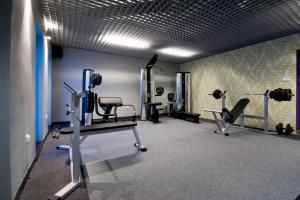 a gym with two treadmills and machines in a room at Hotel Warmia Spa in Braniewo