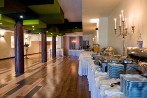 a banquet hall with white tables and white chairs at Hotel Warmia Spa in Braniewo
