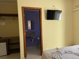 una habitación con una cama y un baño con lavabo en Pousada Werneck Residence Suites, en Ubatuba