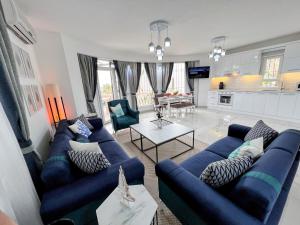 een woonkamer met twee blauwe banken en een keuken bij Entire Villa Lulu Kalkan - Private Pool, free Wi-Fi, Good Location, Breathtaking Sea Views in Kalkan