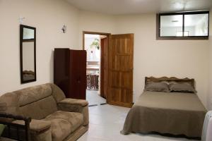 a living room with a bed and a couch at Uma casa inteirinha pra você! in Itanhandu