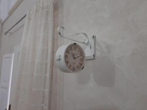un orologio appeso a un muro accanto a una finestra di La Casa delle Zie a Maglie