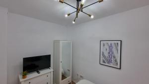 a living room with a television and a chandelier at El Sueño de Sheyla Aguadulce in Aguadulce