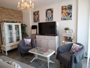 a living room with a tv and two chairs at Apartment Stella in Pula
