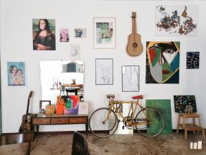 a bike parked in a room with a wall of art at Casita Spagnola in Marsala