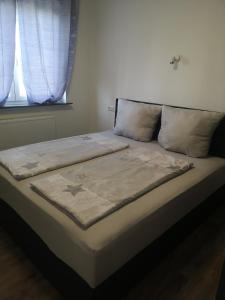 un letto con una coperta e due finestre di Pension Forstfeld Kassel a Kassel