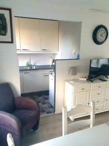 een woonkamer met een bank en een tafel en een keuken bij Beach-house27 in Egmond aan Zee