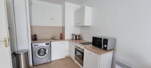 a kitchen with a microwave and a washer and dryer at Proche Disney.Un Superbe appartement bien desservi in Bussy-Saint-Georges