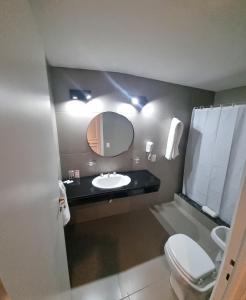 a bathroom with a sink and a mirror and a toilet at HOTEL REGIS in Buenos Aires