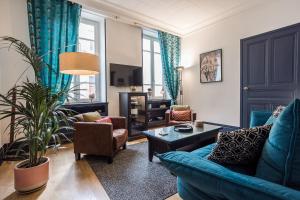 ein Wohnzimmer mit einem blauen Sofa und Stühlen in der Unterkunft VILLA RENEE in Valence