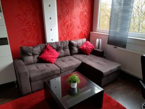 uma sala de estar com um sofá castanho e paredes vermelhas em Fewo Brasilia247 em Schönberg in Holstein