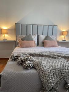 1 dormitorio con 1 cama grande con almohadas rosas en Cantinho do Sol, en Mosteiros
