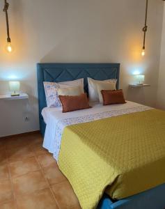 a bedroom with a large bed with a blue headboard at Cantinho do Sol in Mosteiros