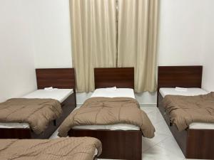 pokój z 3 łóżkami i oknem w obiekcie Short Tourist Place w Dubaju