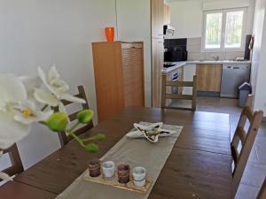 een keuken met een houten tafel en een eetkamer bij La clé des champs in Clam