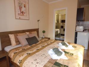 - une chambre avec un grand lit et des serviettes dans l'établissement Völgy Apartman, à Eger