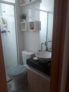 a white bathroom with a sink and a toilet at Apartamento em Cuiabá in Cuiabá