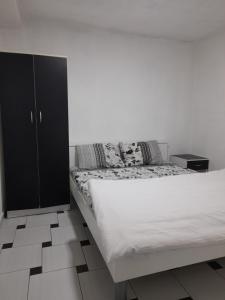 a bedroom with a bed and a black cabinet at Apartments 64 in Star Dojran