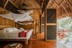 a bedroom with a bed and a hammock in a room at Dos Aguas Lodge in Rincón