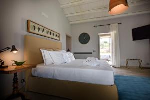 a bedroom with a bed and a table and a window at Poggio Leano Boutique Hotel in Donnalucata
