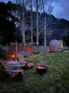 a backyard with a table and chairs and a fire pit at Enniskeen Estate & Forest Spa - Boutique Riverside Glamping Cabins in Newcastle