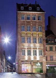 ein hohes Gebäude in der Nacht auf einer Stadtstraße in der Unterkunft Hotel Drei Raben in Nürnberg