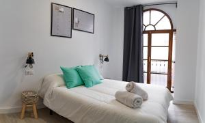 a bedroom with a bed with green and white pillows at ESPINEL APARTMENTS in Ronda