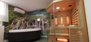 a bathroom with a bath tub and a waterfall mural at Plitvice Inn in Jezerce