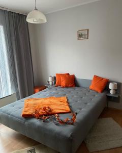 a bedroom with a large bed with orange pillows at Stan na dan Oplenac in Topola