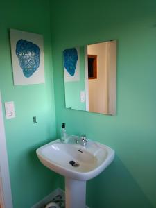 La salle de bains est pourvue d'un lavabo blanc et d'un miroir. dans l'établissement El Corralon de Severo, à Hinojales