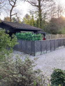 uma cerca com um jardim em frente a um edifício em Maison De L'amitié em Lanton