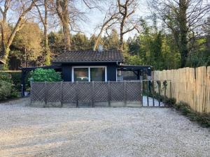 ein kleines Haus mit einem Zaun davor in der Unterkunft Maison De L'amitié in Lanton