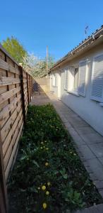 una cerca frente a una casa con un patio en Charmante maison cosy T2 avec terrasse en Tremblay En France