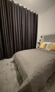 una camera da letto con un grande letto con tende nere di Modern & Bright, G/F, 1BR APT. Real Hidden Gem a Hamilton