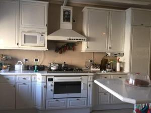 a kitchen with white cabinets and a stove top oven at Petra Villa in Wadi Musa