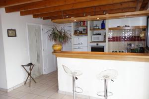eine Küche mit einer Bar mit zwei Hockern in der Unterkunft Maison sur la colline cheminée WIFI proche Thermes in Aubin + 27 Fotos