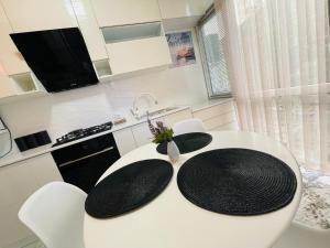 a white kitchen with a white table and chairs at Yas Apartment in Samarkand