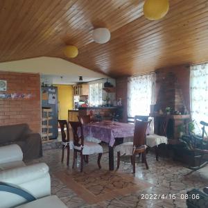 una sala da pranzo con tavolo e alcune sedie di Refugio MALUAN.. Cabaña Villa Nepo a Paipa