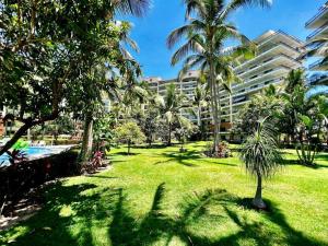 a park with palm trees and a large building at Beachfront 2 bedroom Condo in Playa Royale Resort, Nuevo Vallarta in Nuevo Vallarta 