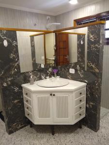 a bathroom with a white sink and a large mirror at Chale Aroma da Serra in Monte Verde