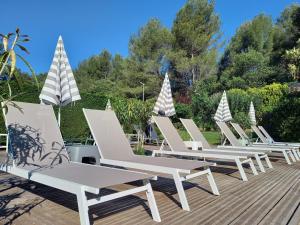 une rangée de chaises longues blanches sur une terrasse dans l'établissement Résidence Royal Palmeraie, à Aubagne