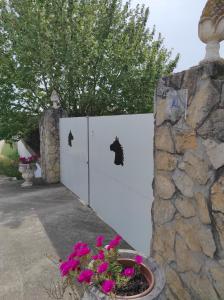 un cancello bianco con un muro in pietra e fiori di Fazenda do Marante a Tomar