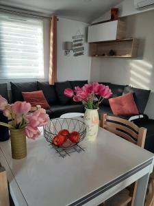 - un salon avec une table fleurie et un canapé dans l'établissement LA CARABASSE CP90, à Vias