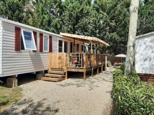 a mobile home with a porch and a deck at LA CARABASSE CP90 in Vias