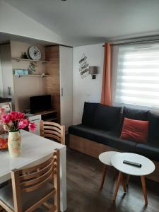 - un salon avec un canapé noir et une table dans l'établissement LA CARABASSE CP90, à Vias