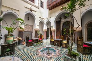 un patio con sillas y mesas en un edificio en Riad Le Moucharabieh en Fez