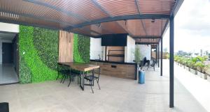 an outdoor patio with a table and a green wall at “SC Apartments” Equipetrol in Santa Cruz de la Sierra