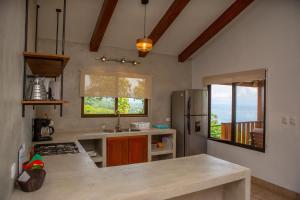 a kitchen with a counter top and a refrigerator at Villas Alturas in Dominical