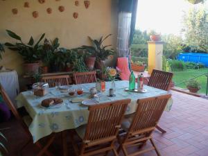 ein Tisch mit Stühlen und ein Tischtuch auf einer Terrasse in der Unterkunft Tavernamici in Anguillara Sabazia
